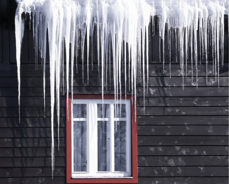 Large icicles and ice dam formation on a black home on the South Shore of Nova Scotia