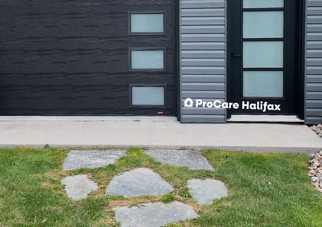 A cleaned concrete walkway that was covered in dark organic growth, dirt buildup, and heavy atmospheric staining before a professional pressure washing treatment in Cole Harbor.