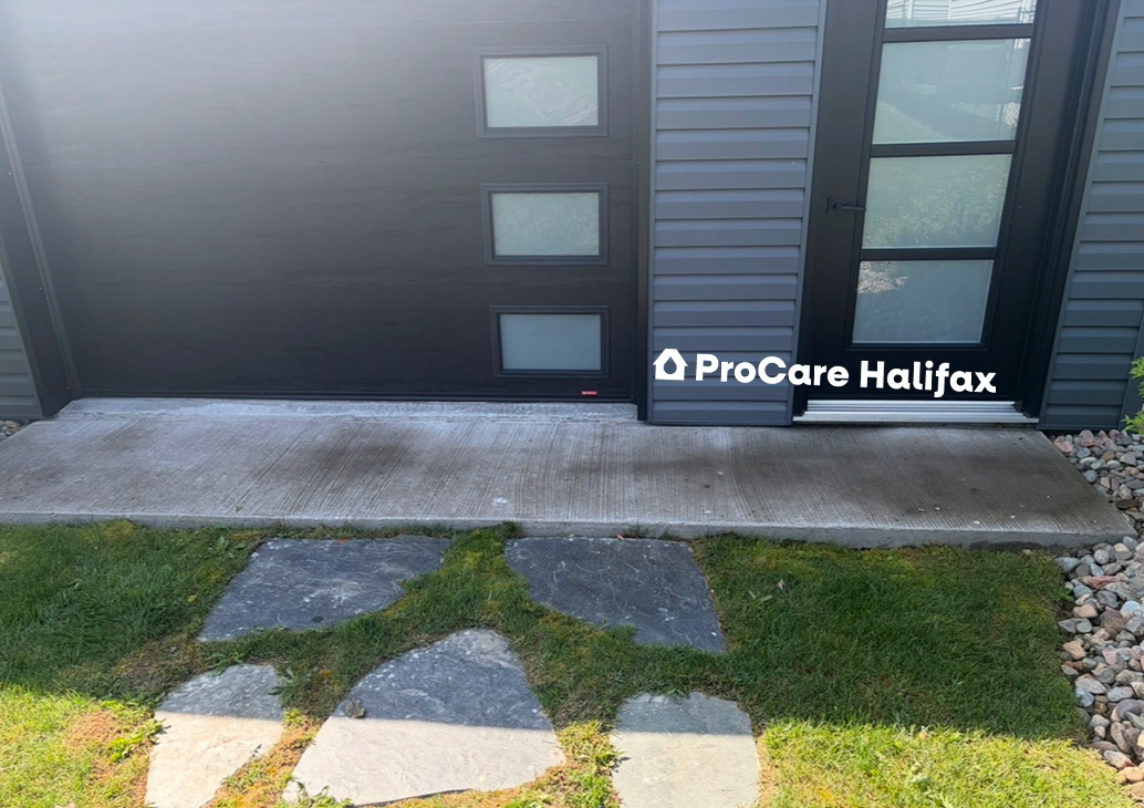 A concrete walkway covered in dark organic growth, dirt buildup, and heavy atmospheric staining before a professional pressure washing treatment in Cole Harbor.